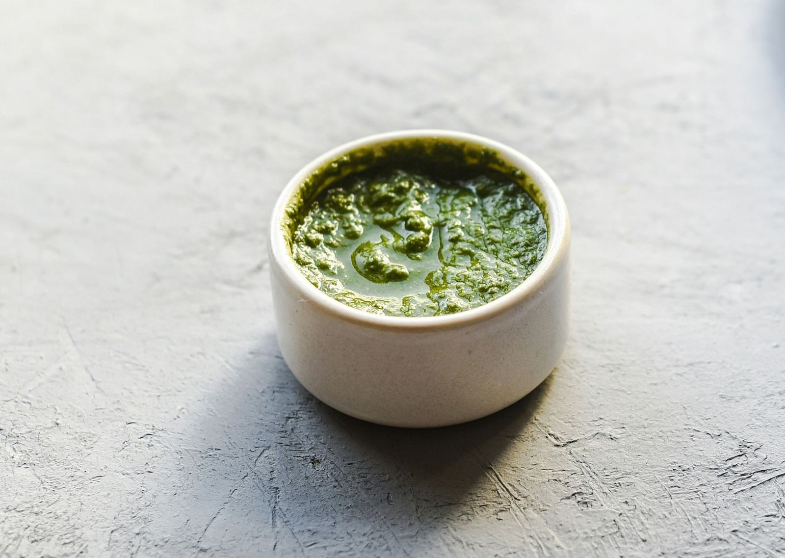 An overview of a dish placed next to a bowl of green chutney.