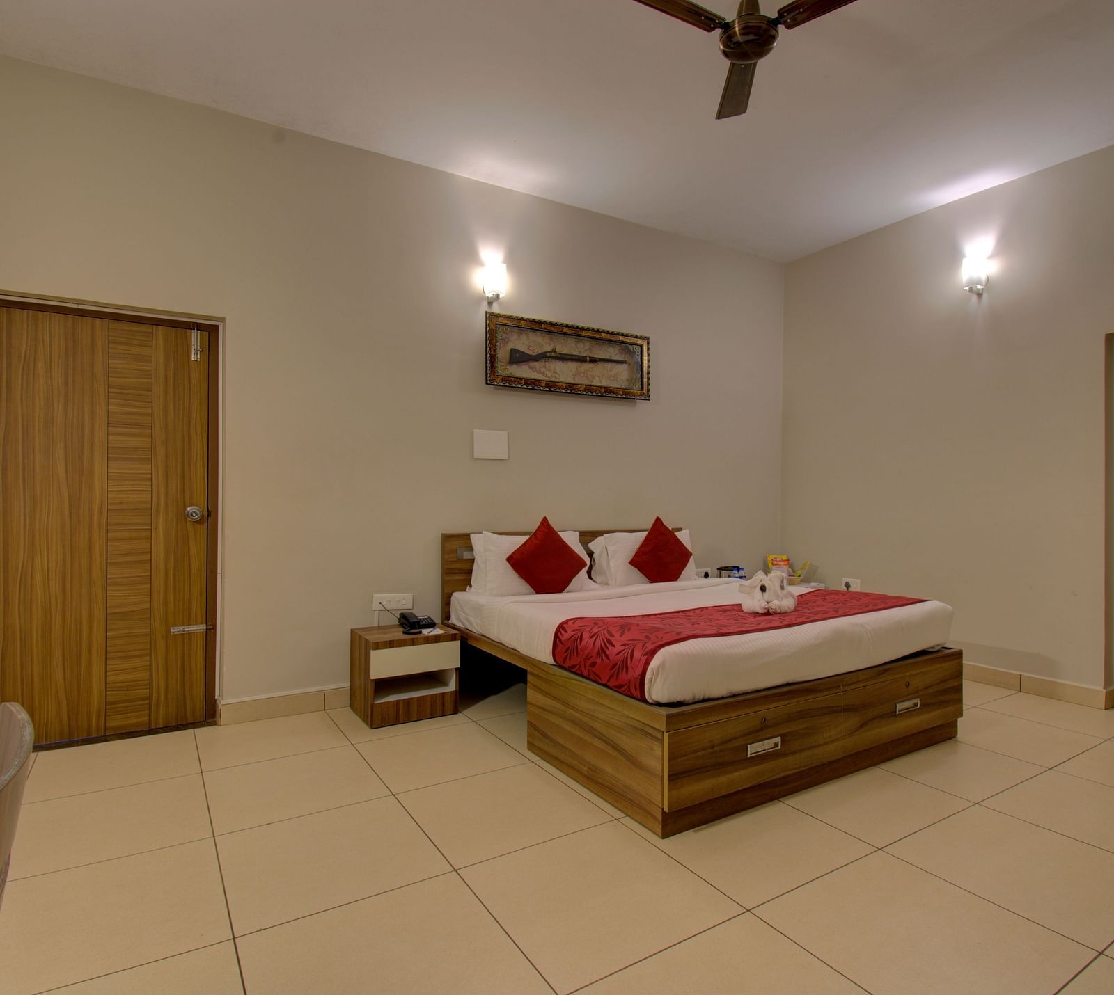 Bedroom with a double bed, side table, tiled floor, ceiling fan and wooden doors | Superior Room | Woodstock Resorts, Coorg