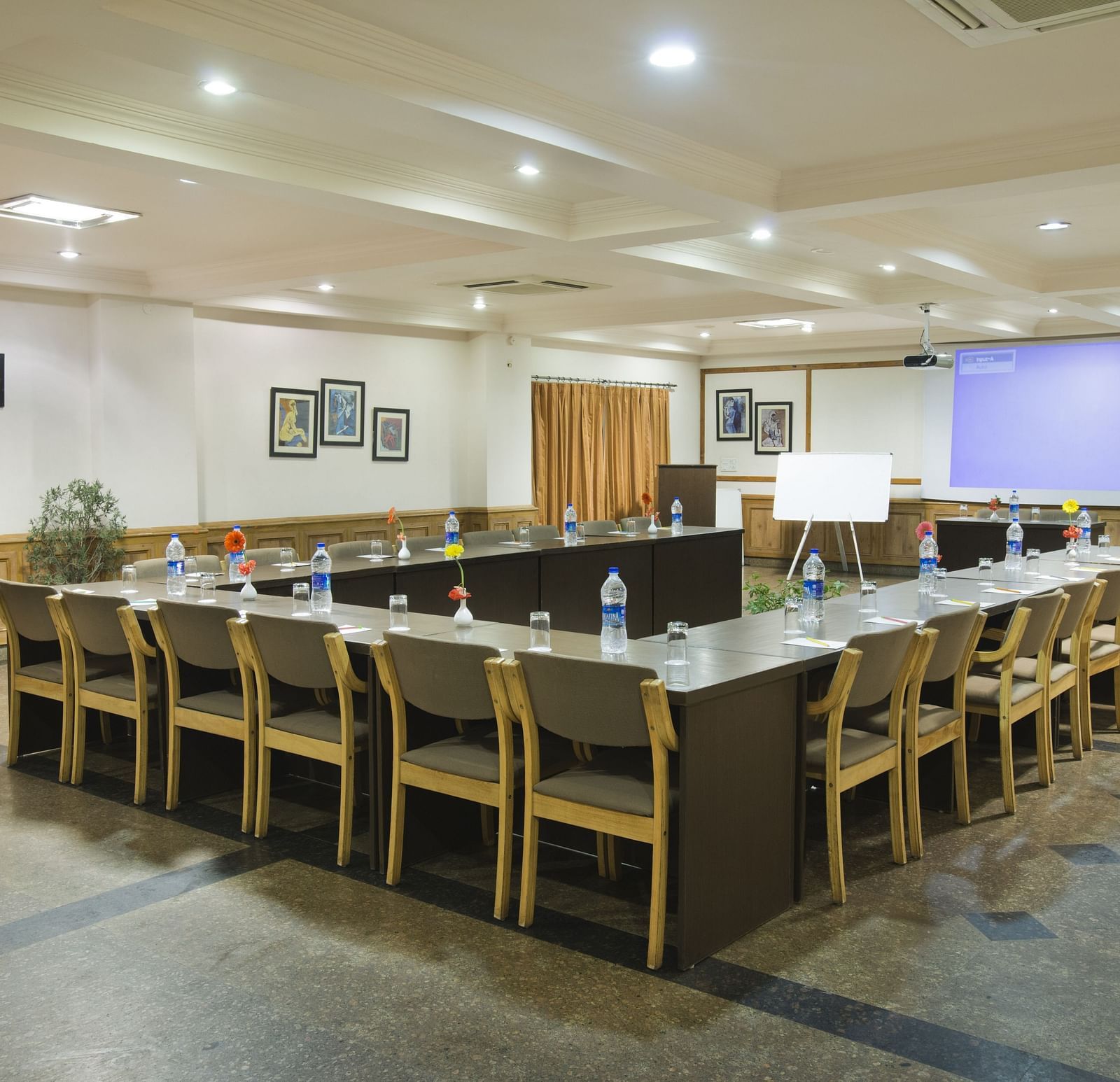 a corner view of a conference room with a U-shaped seating arrangement 