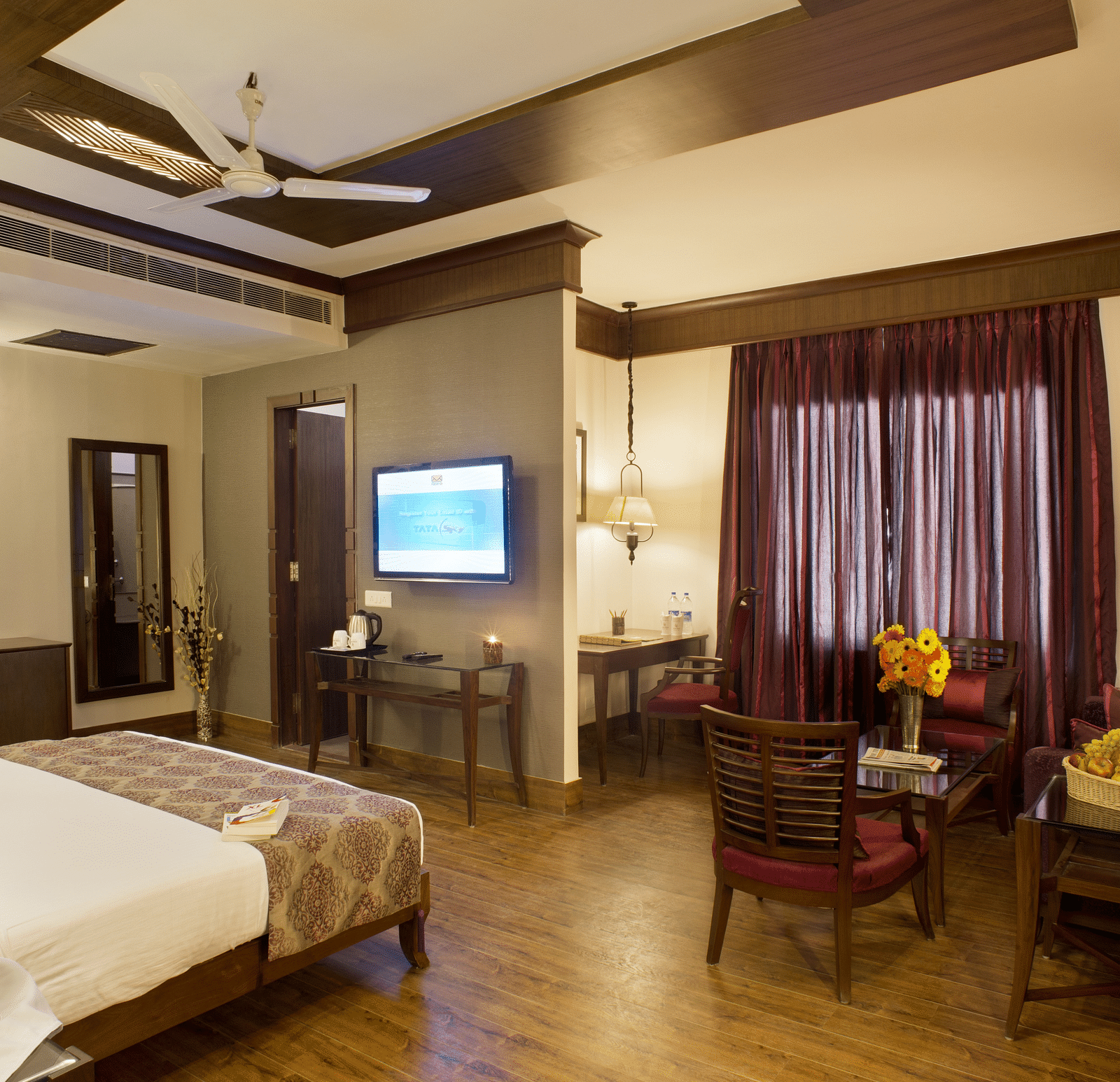 A view of a bedroom with a single bed facing a television and a desk with chairs - The Manor, Kashipur