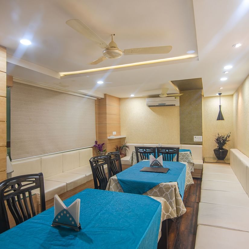 A restaurant with several tables and chairs - Hotel Morya, Bhopal
