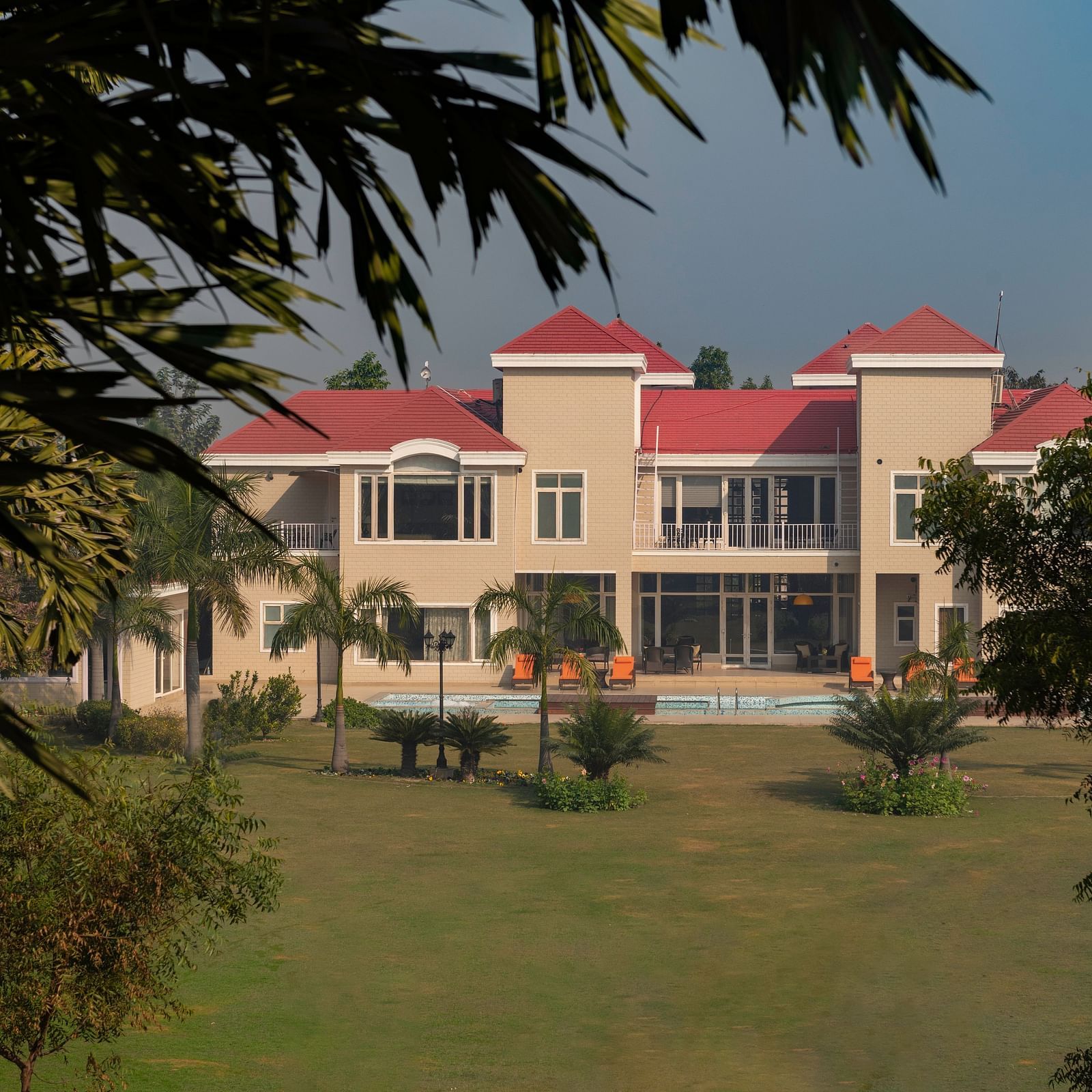Facade view of BluSalzz Resort with garden and trees in the front.