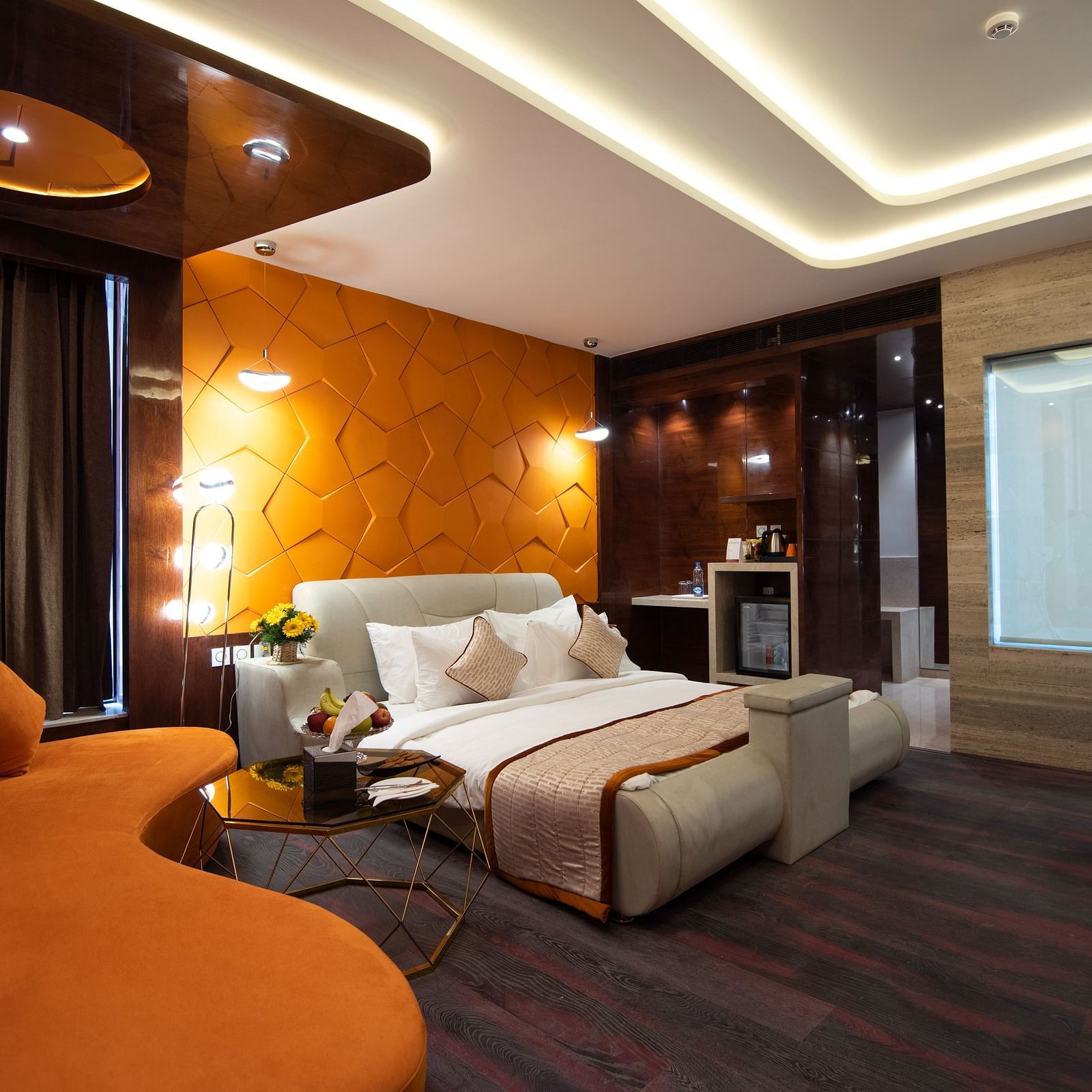 Junior Suite decked with a comfy bed and orange sofa at Hotel Park Elanza, Coimbatore