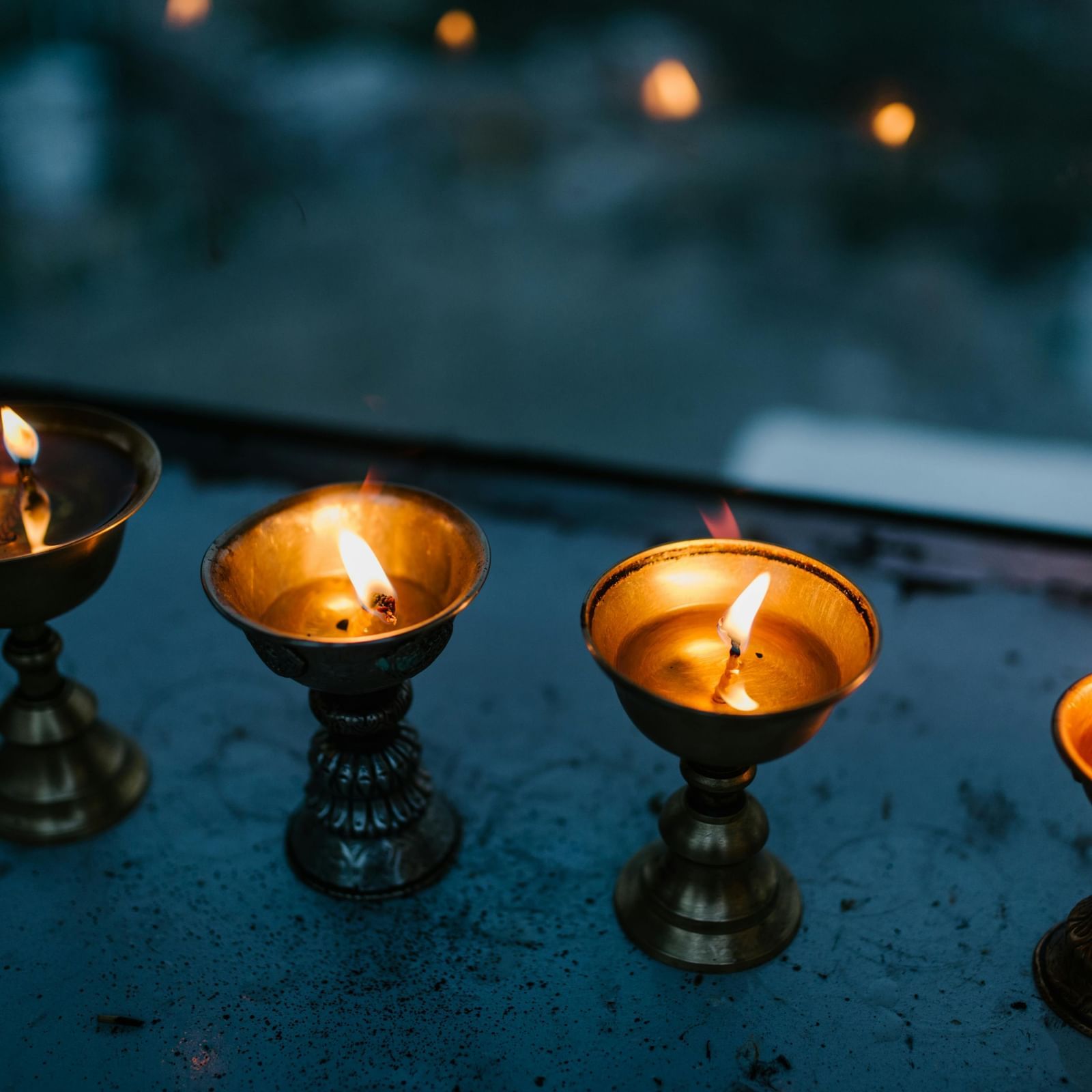 Small lit dias lined up on a polished black surface.