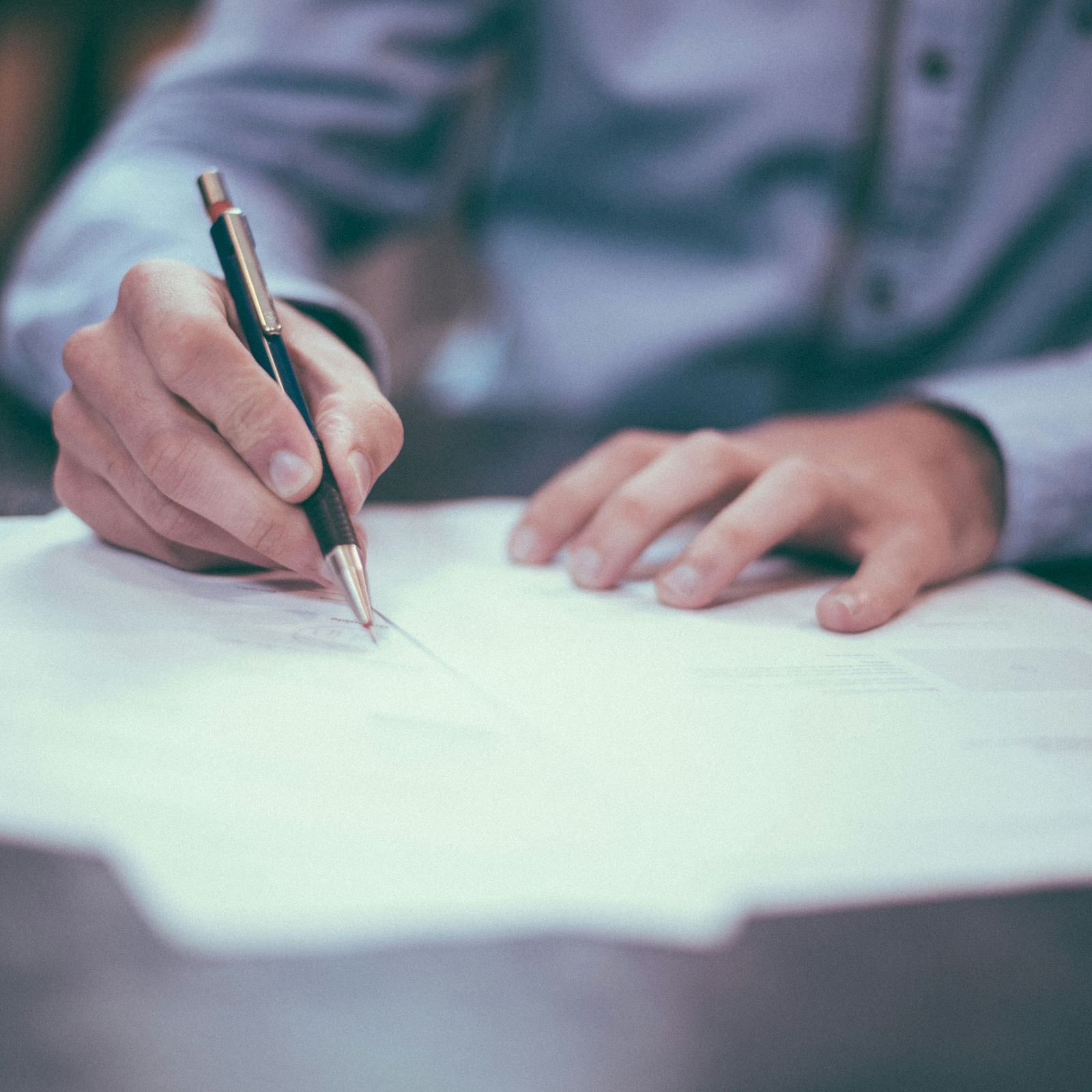 A person writing on a sheet of paper