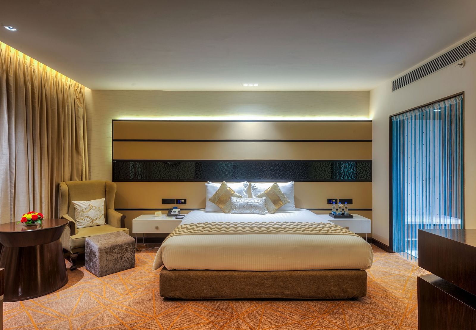 Theme Suite with a king size bed and a sofa chair at Grand Chennai By GRT Hotels.