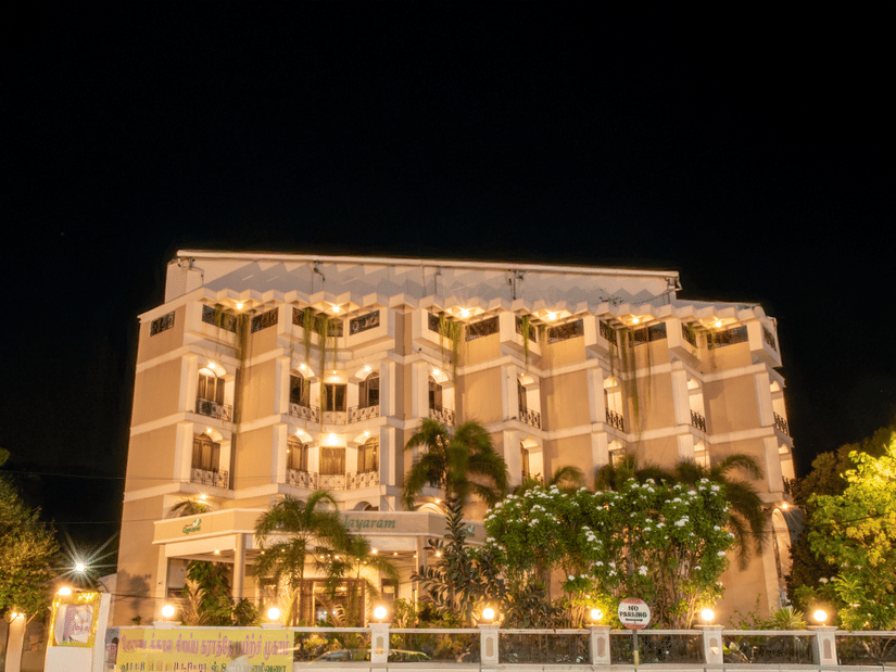 Night view of Jayaram Hotel, Pondicherry showcasing the illuminated hotel façade and inviting entrance.