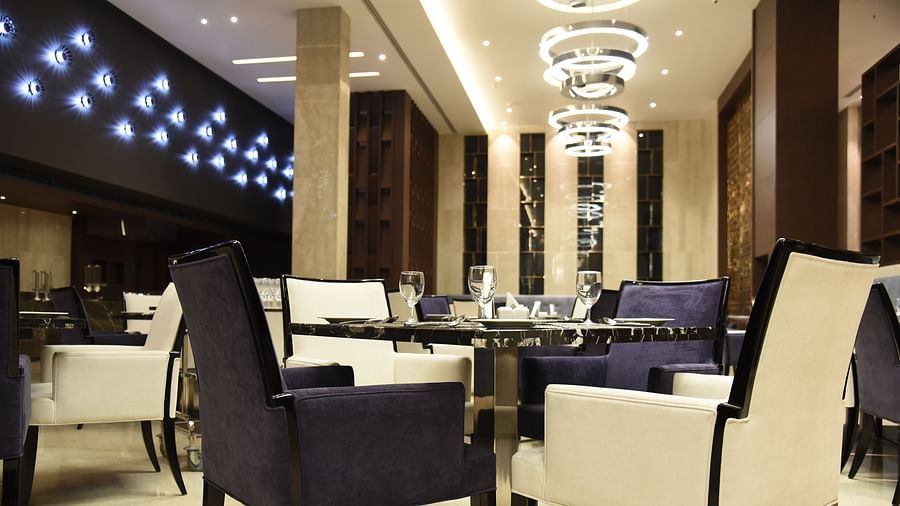  A dining area with warm lighting and inviting décor, where tables are elegantly set for guests to enjoy their meal