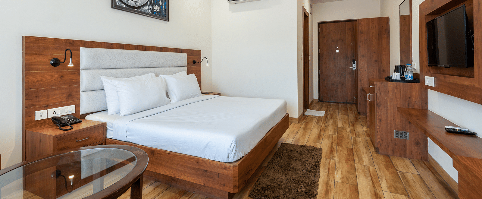 Premium room featuring a tea and coffee maker, air-conditioning, and a Buddha portrait above the bed at DLS The Classio