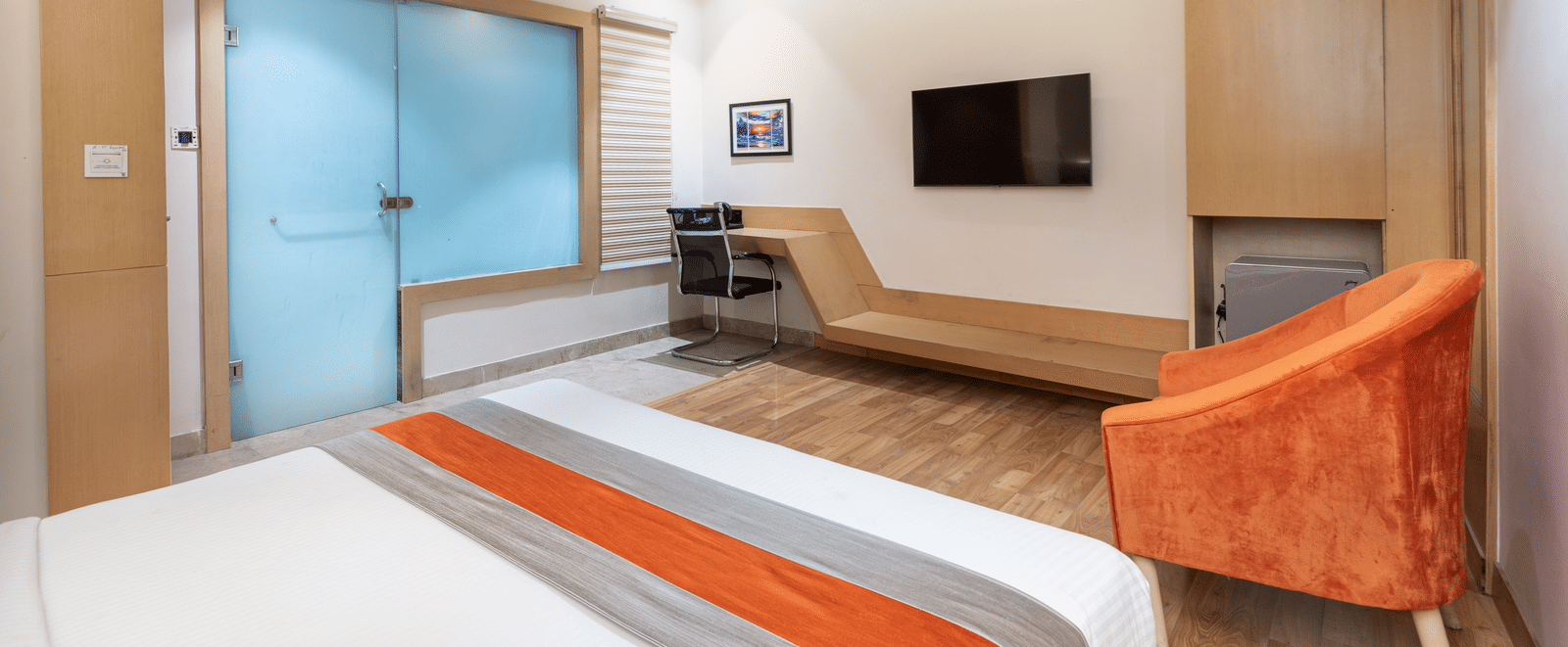 View of a spacious guest room at DLS Tehri Club Resort featuring a king size bed and a lounge area.