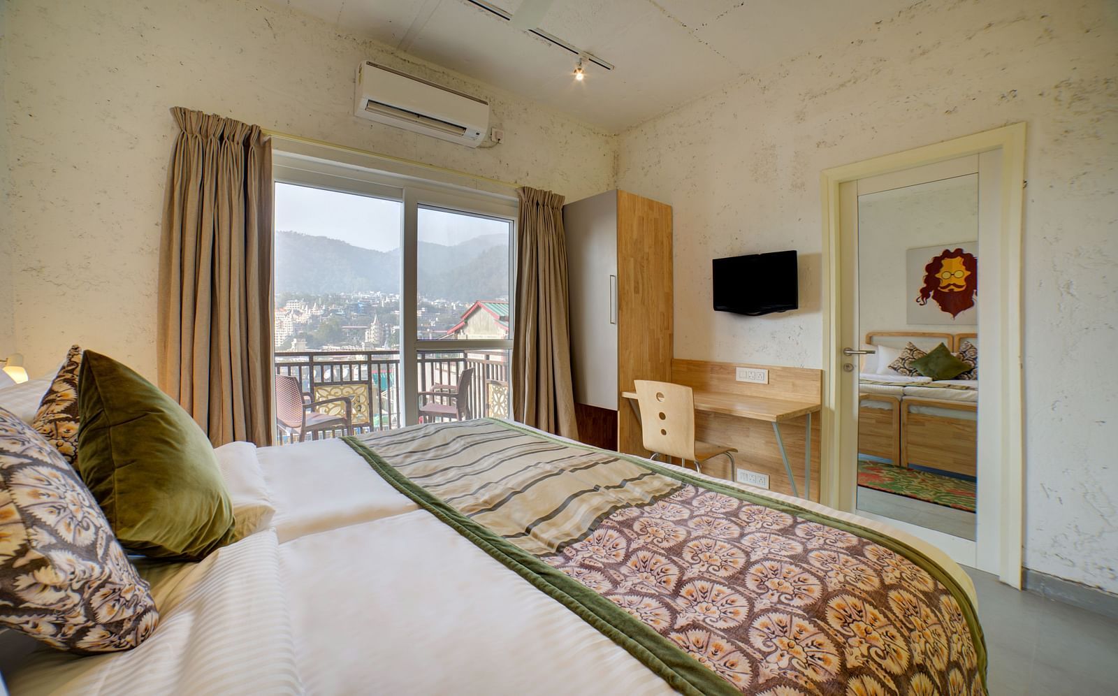Side view of a room with an air-conditioner and a large bed facing a television - Bedzzz, Rishikesh