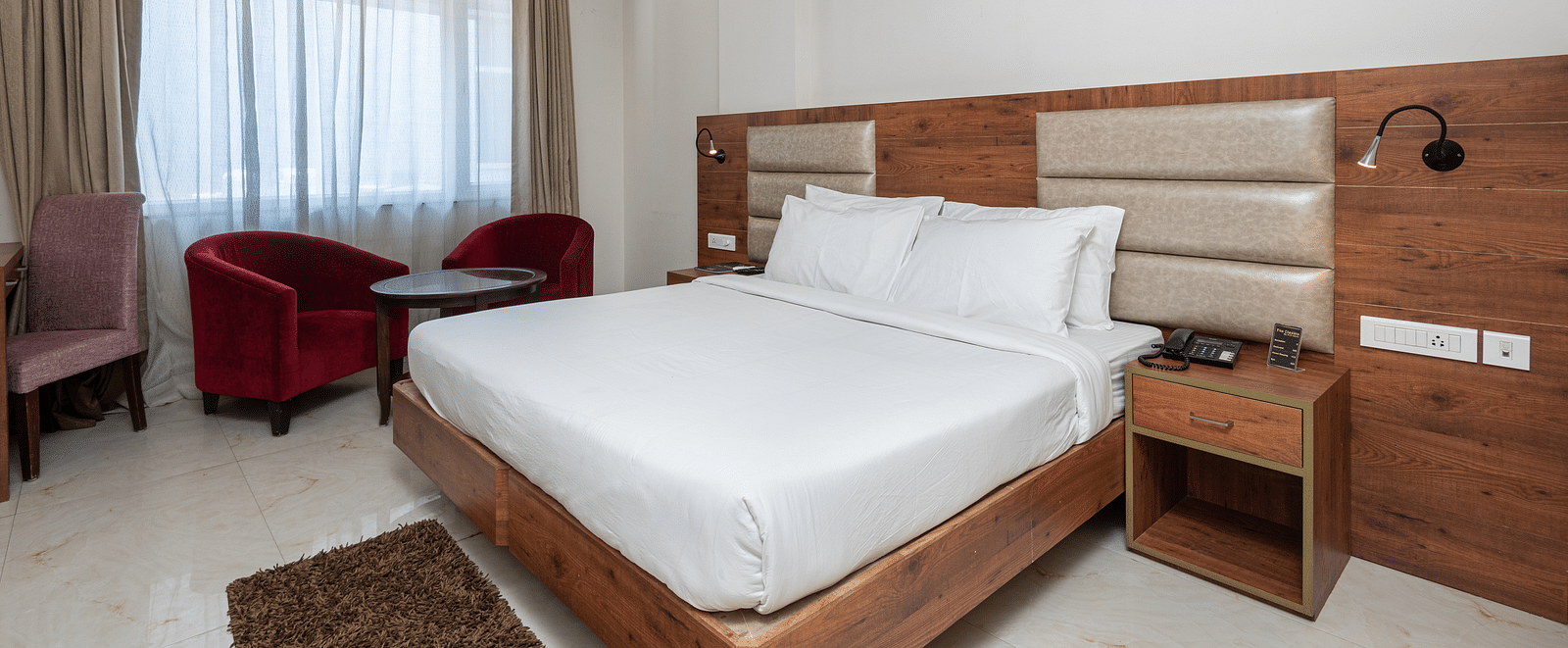  Premium room with a king size bed featuring a stylish headboard, and a window adorned with a soft sheer curtain at DLS The Classio