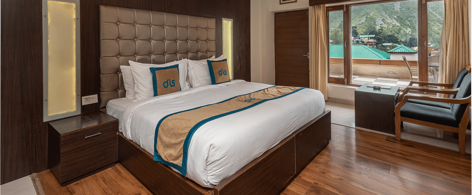 A Premium Room at DLS Spring Valley Resort Dharamshala featuring a king size bed, chair and a balcony