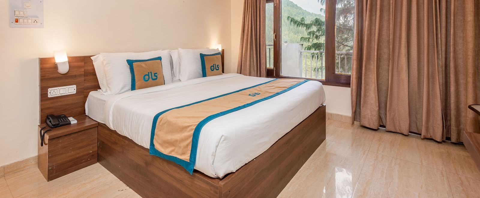 Image of a room featuring a king size bed with a side table, marble flooring and an expansive window | DLS Anupam Resort, Dharamshala