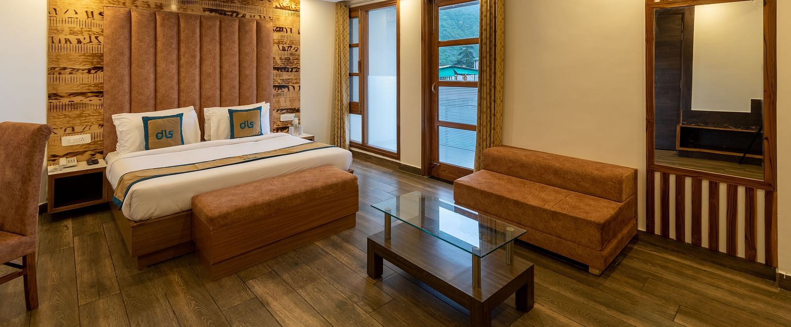 A stylish premium room with a large bed, modern furniture, and mountain views, offering a cosy and relaxing atmosphere - DLS Meghavan Resort, Dharamshala