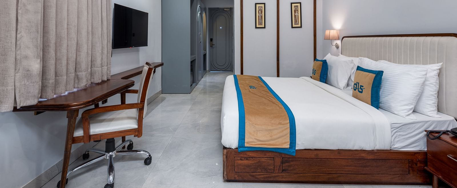 Spring Suite at DLS Spring Valley Resort Dharamshala featuring a kind bed, work desk and chair and ambient lighting