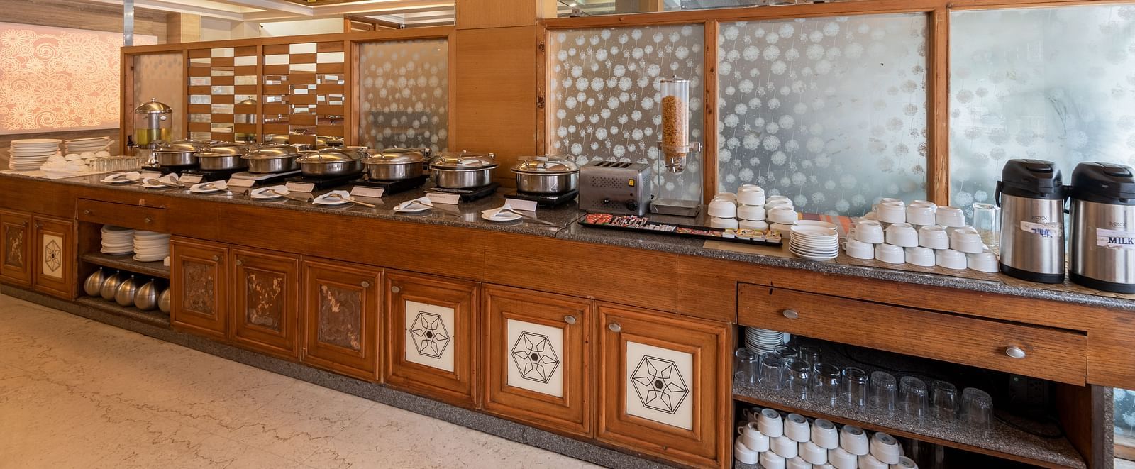Buffet table at Ruttba restaurant of DLS Spring Valley Resort Dharamshala with food and other cutlery kept