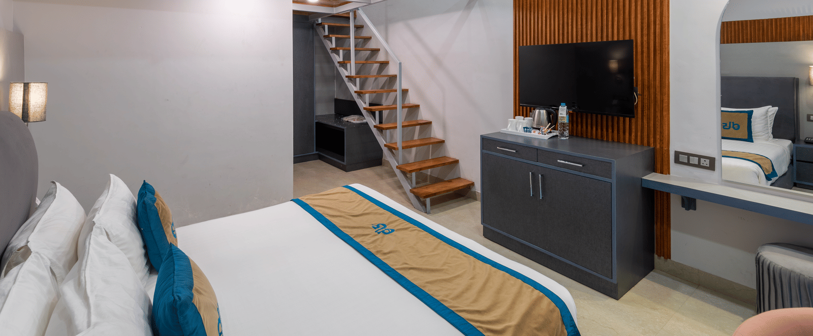 Spring Duplex Room at DLS Spring Valley resort Dharamshala featuring a king bed table, chairs and stairs leading to second story