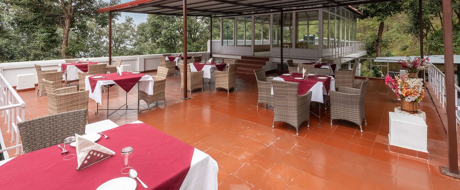 Image of the open air restaurant at DLS Tehri Resort with chairs and tables arranged.