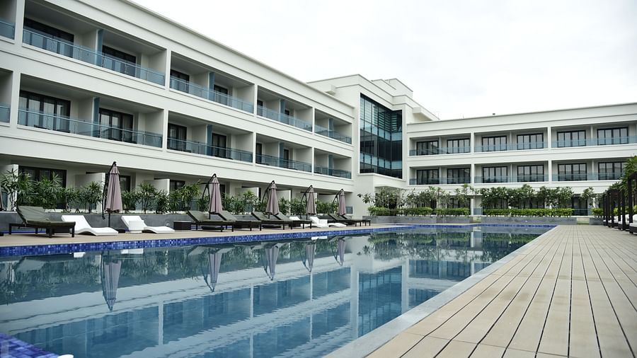 A facade view of the hotel, with the reflection of the building in the swimming pool