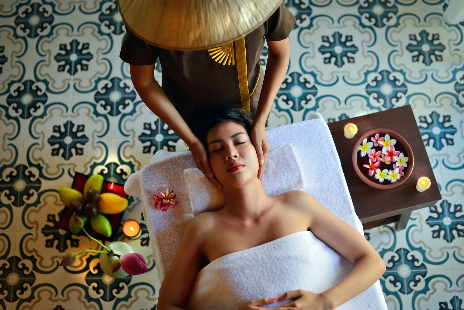 A masseuse providing a massage to a woman who is lying face up