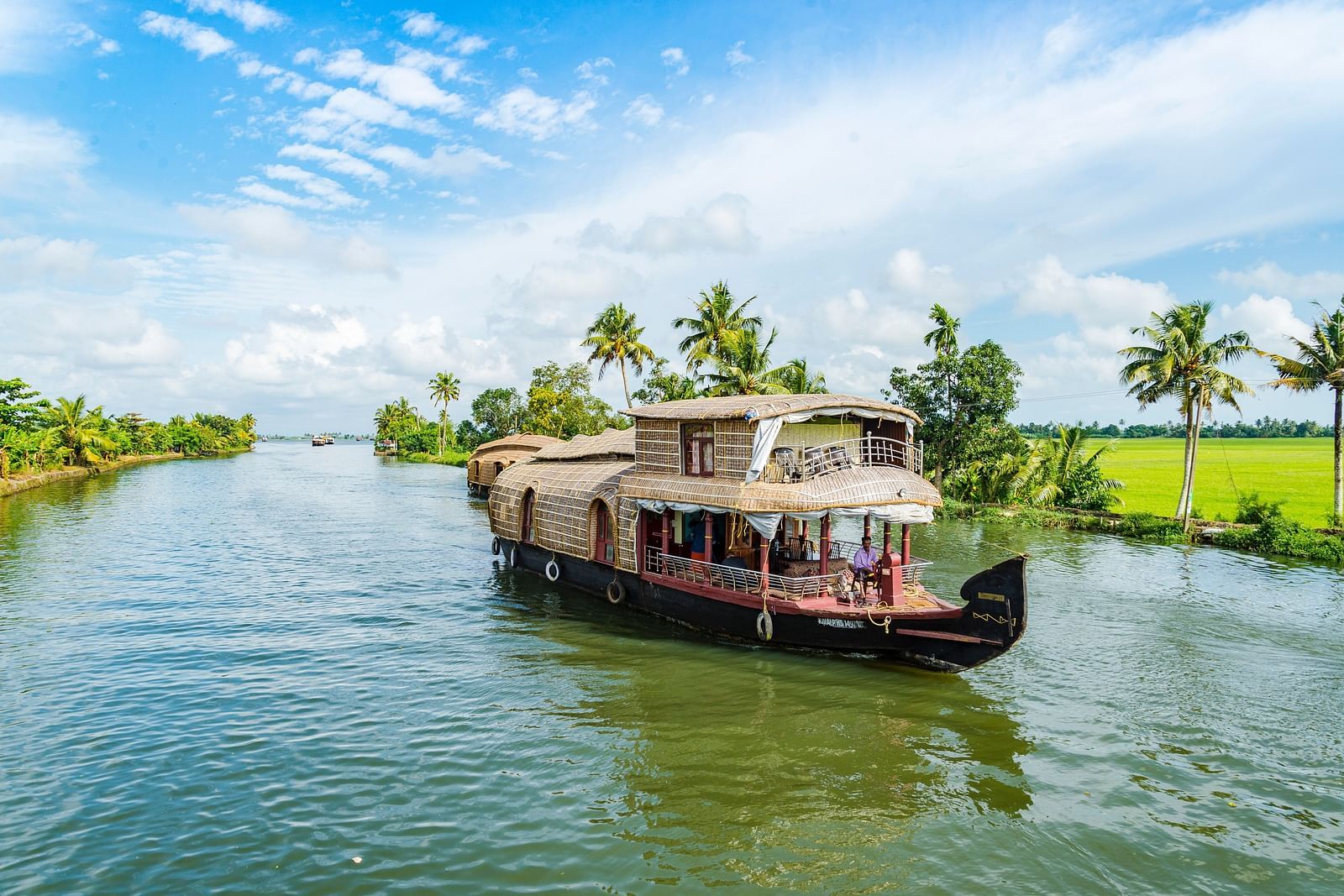 an image Kerala houseboat glides smoothly through the backwaters - Kumarakom Tourism