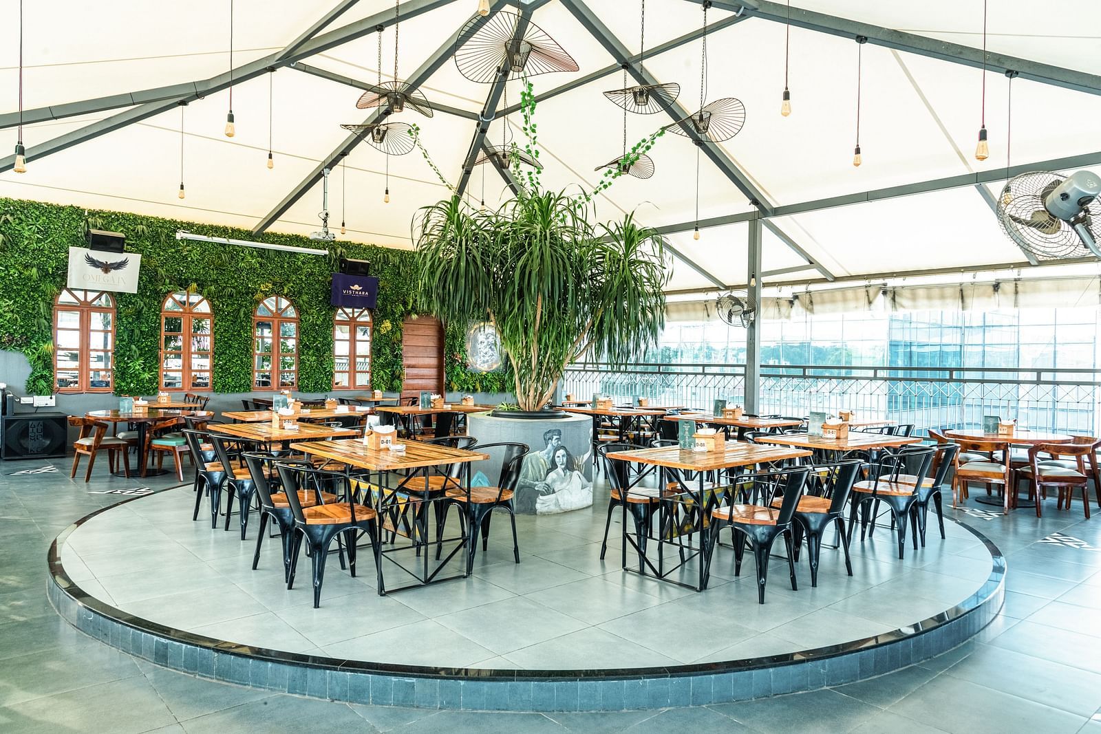A wide view of chairs and table at a circular stand at Kyba restaurant at Visthara - Urban Boutique Hotel 12