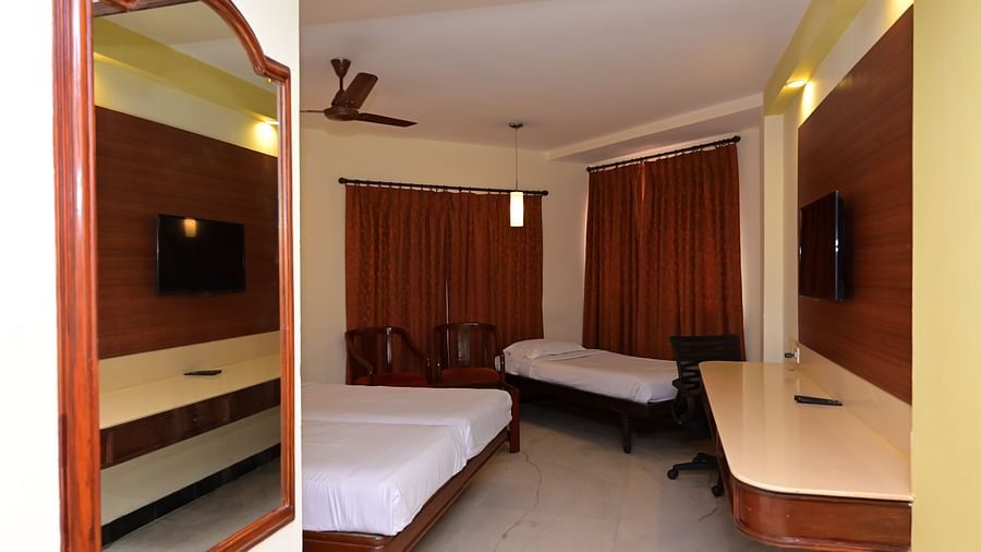 View of Standard Room for triple occupancy with partial view of plush bed and basic amenities - Jayaram Hotel, Pondicherry