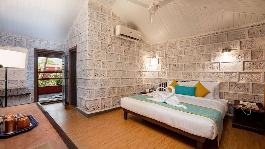 Lotus eco beach resort, king size bed and side table at Konkan Cottage