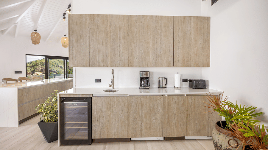 A kitchen area at the Tamarind Hills Resort and Villas, Antigua, with a sink, appliances and cabinets.