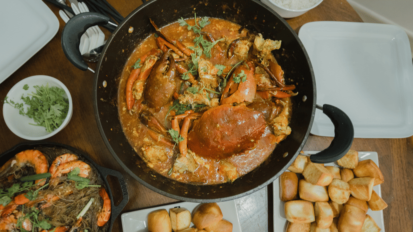 A bowl of crab stew placed beside other plates of food at Heritage Village Resort & Spa, Goa.