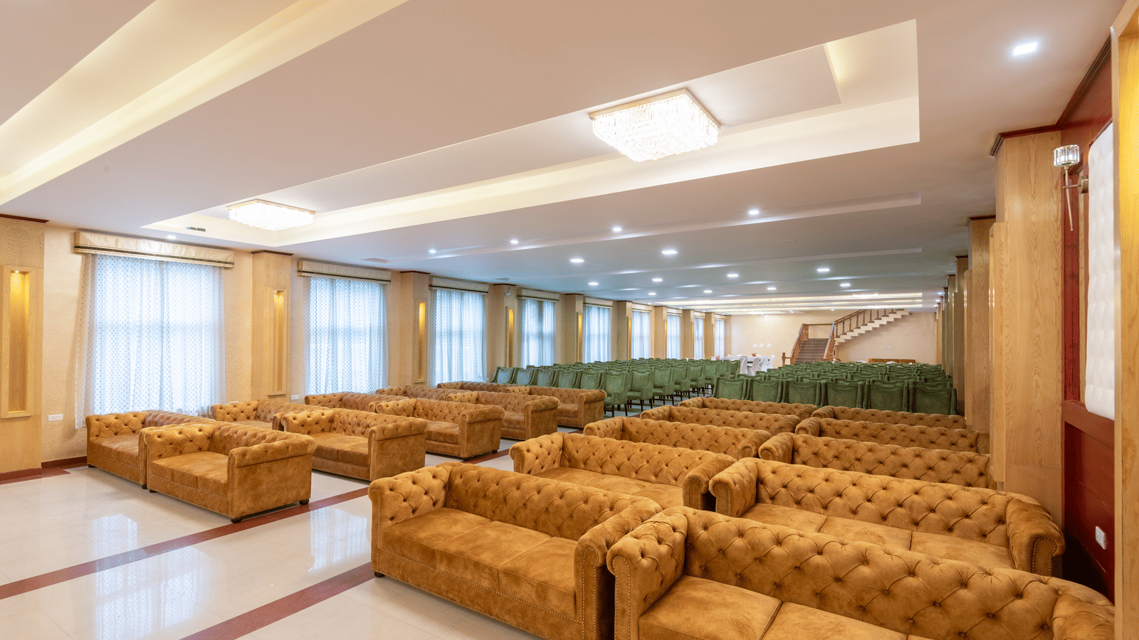 An expansive banquet hall at DLS Hotels with plush seating arrangements and bright recessed ceiling lighting.