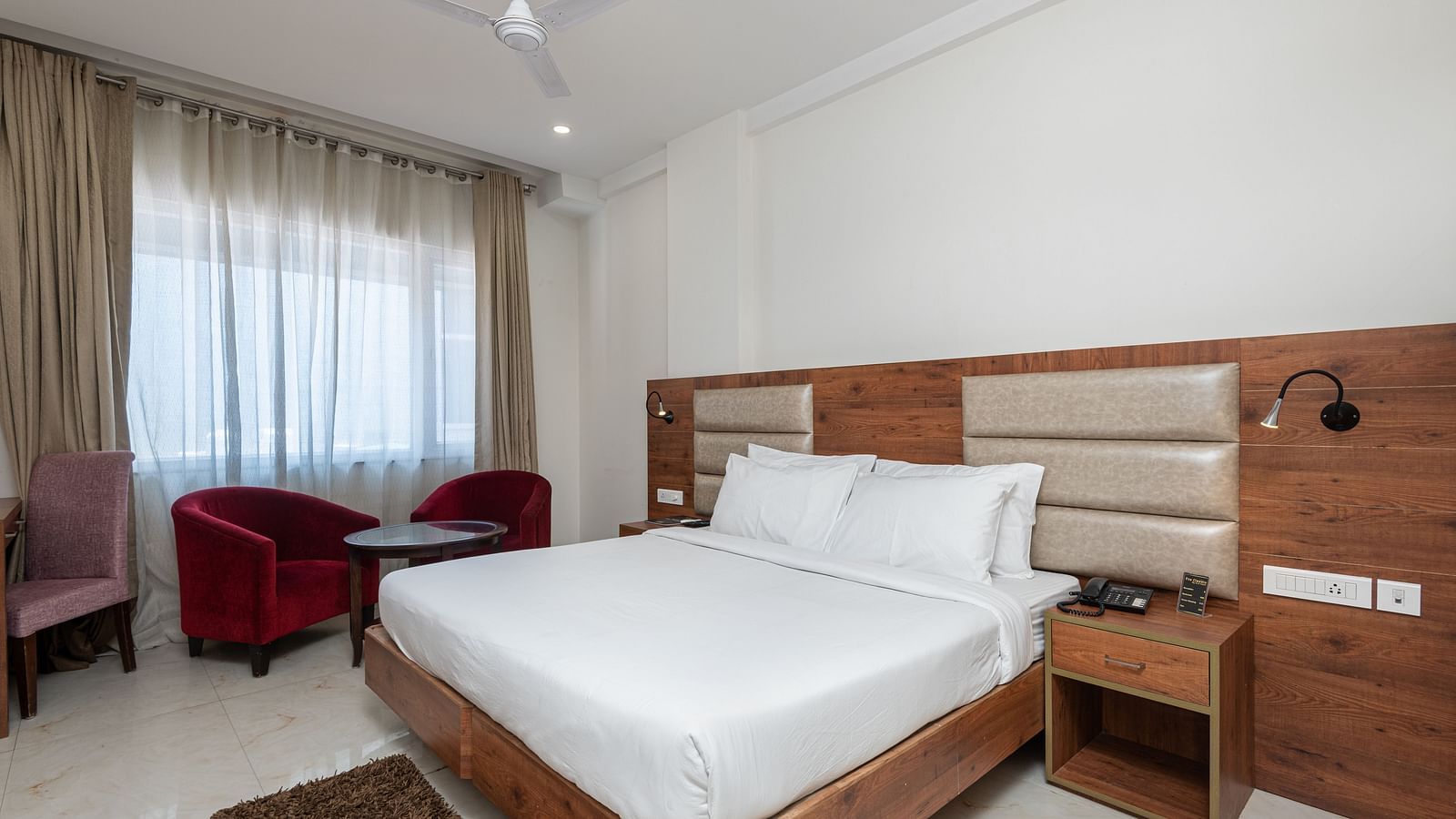 Premium room with a king size bed featuring a stylish headboard, and a window adorned with a soft sheer curtain at DLS The Classio