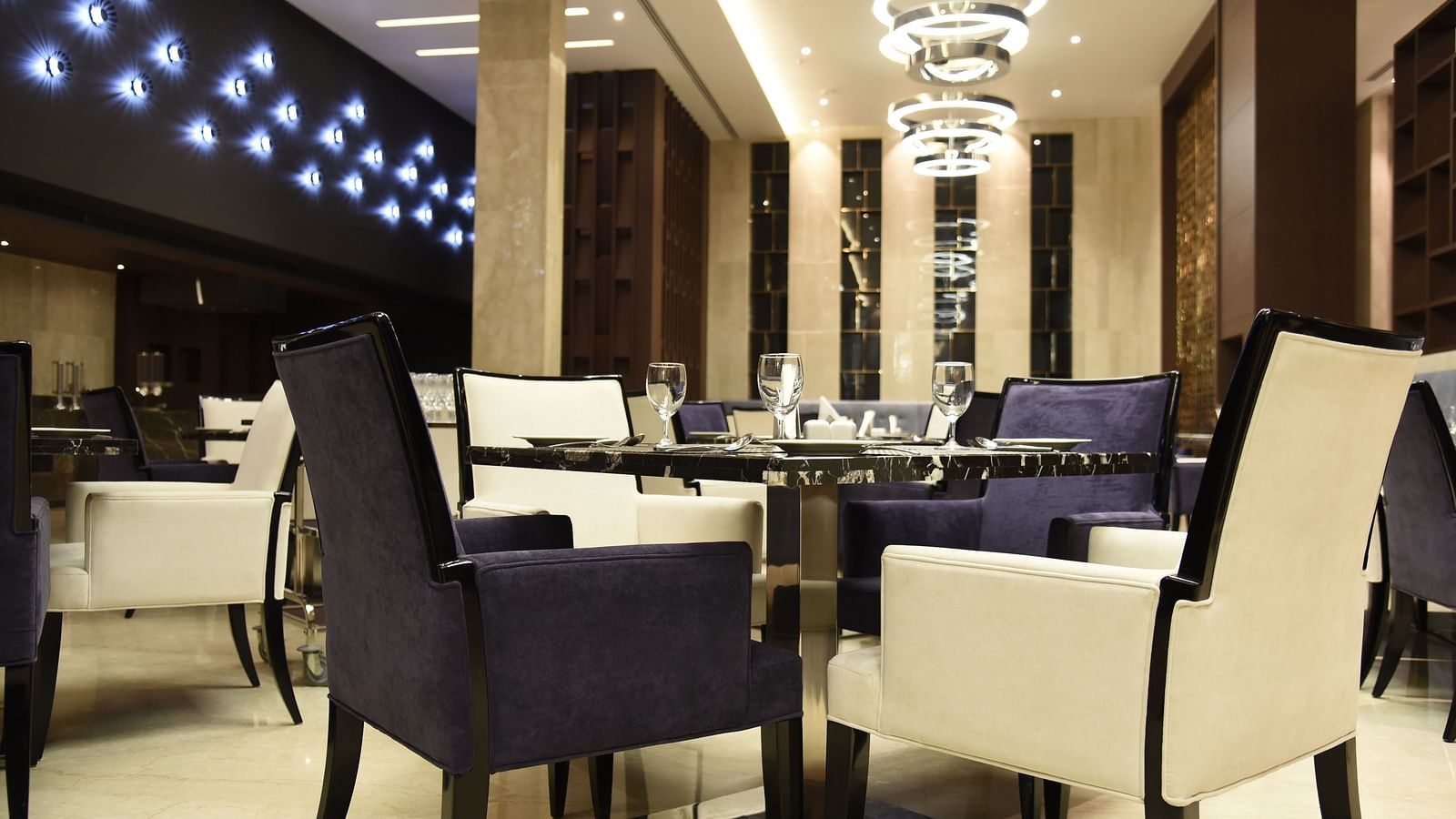  A dining area with warm lighting and inviting décor, where tables are elegantly set for guests to enjoy their meal