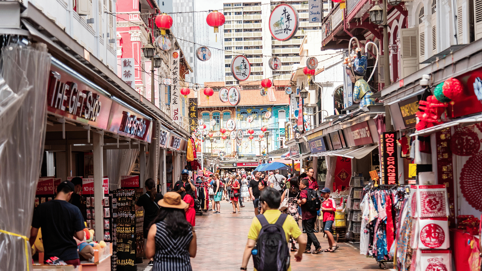 a street with chinese restaurants and chinese lanterns hanging overhead