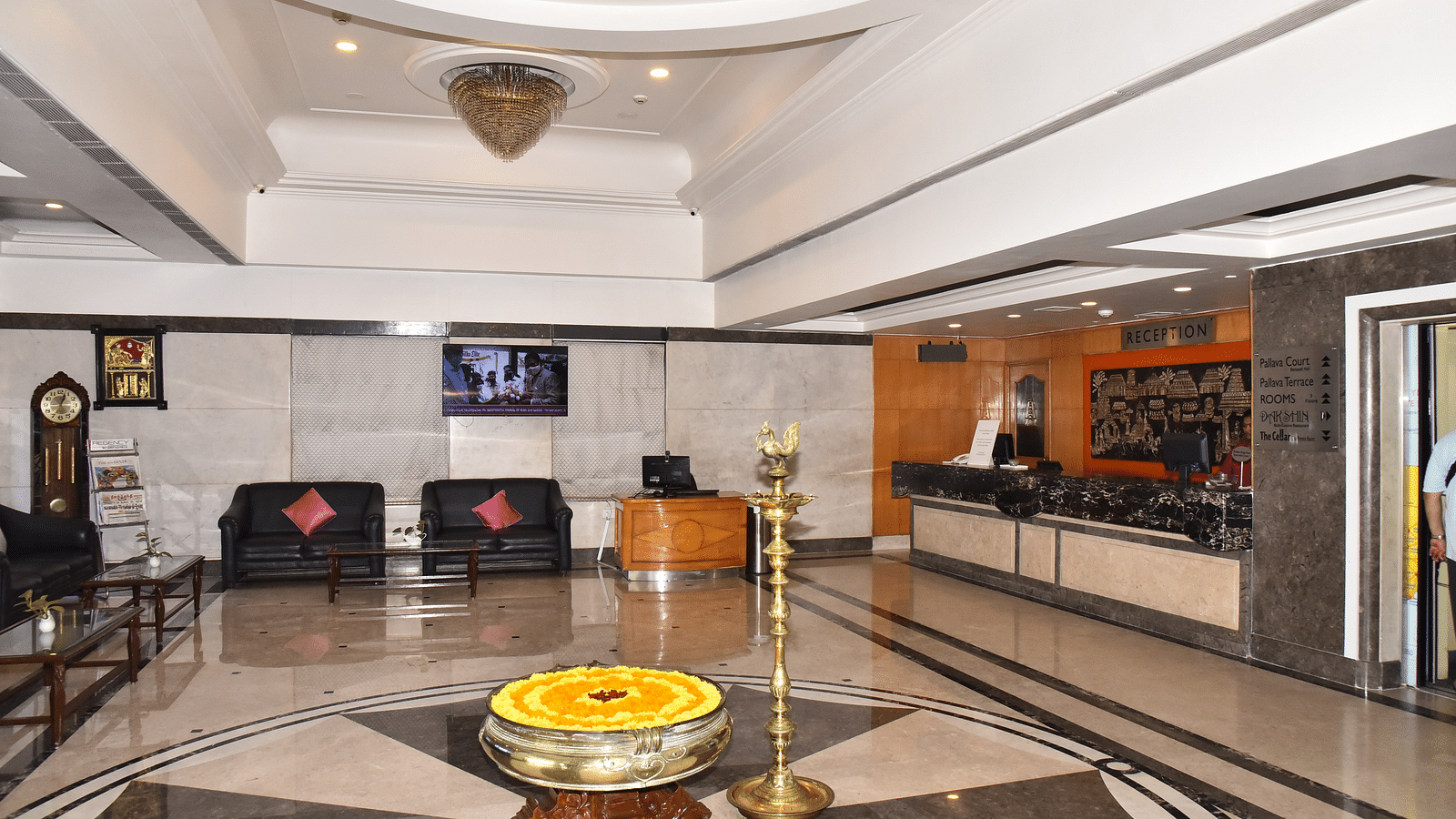 A facade view of the lobby featuring seating for guests and a reception desk to welcome them - Regency Kanchipuram by GRT Hotels