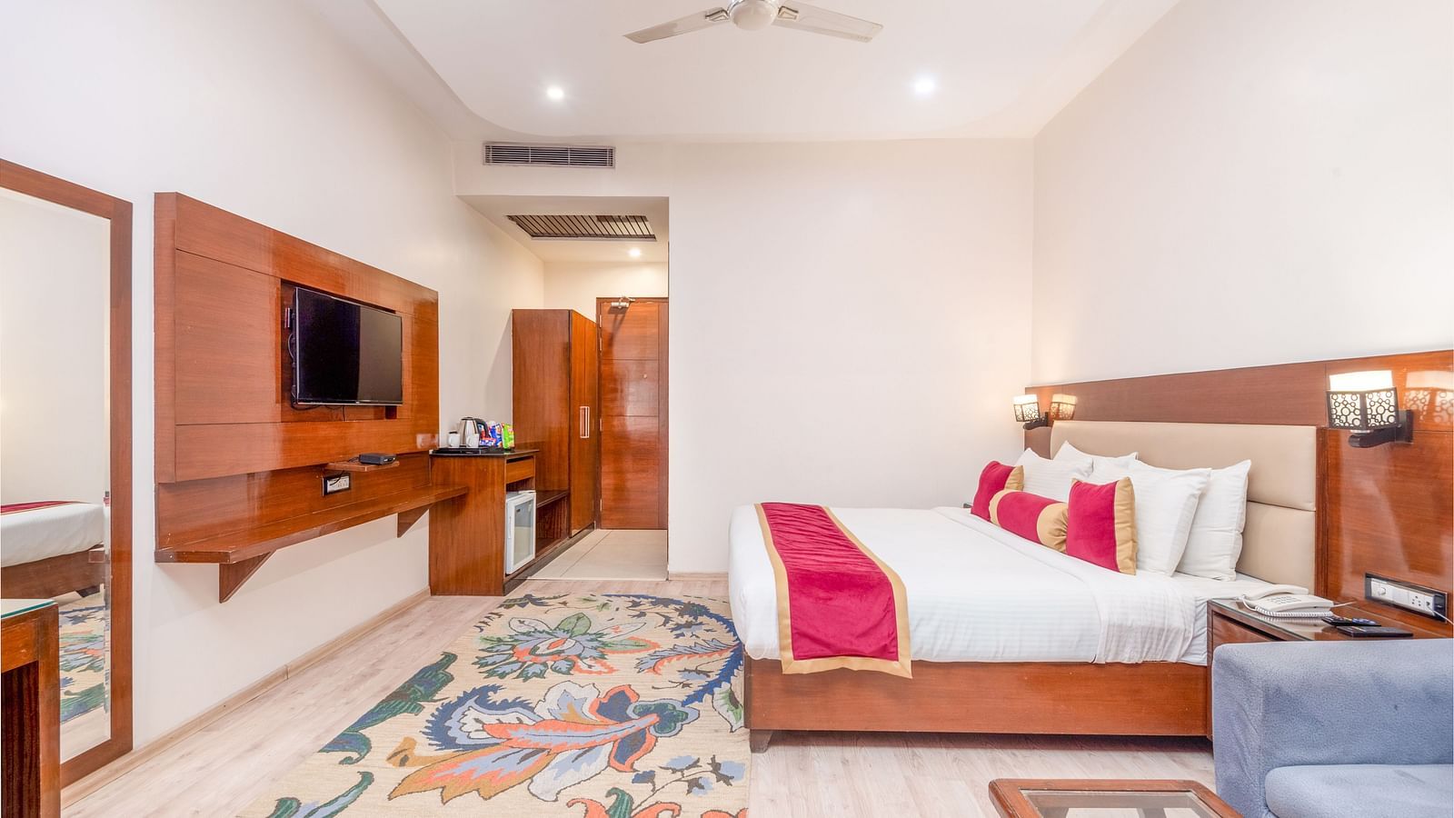 Spacious suite with bed, sofa, and TV at Regenta Inn DLS, Rishikesh.