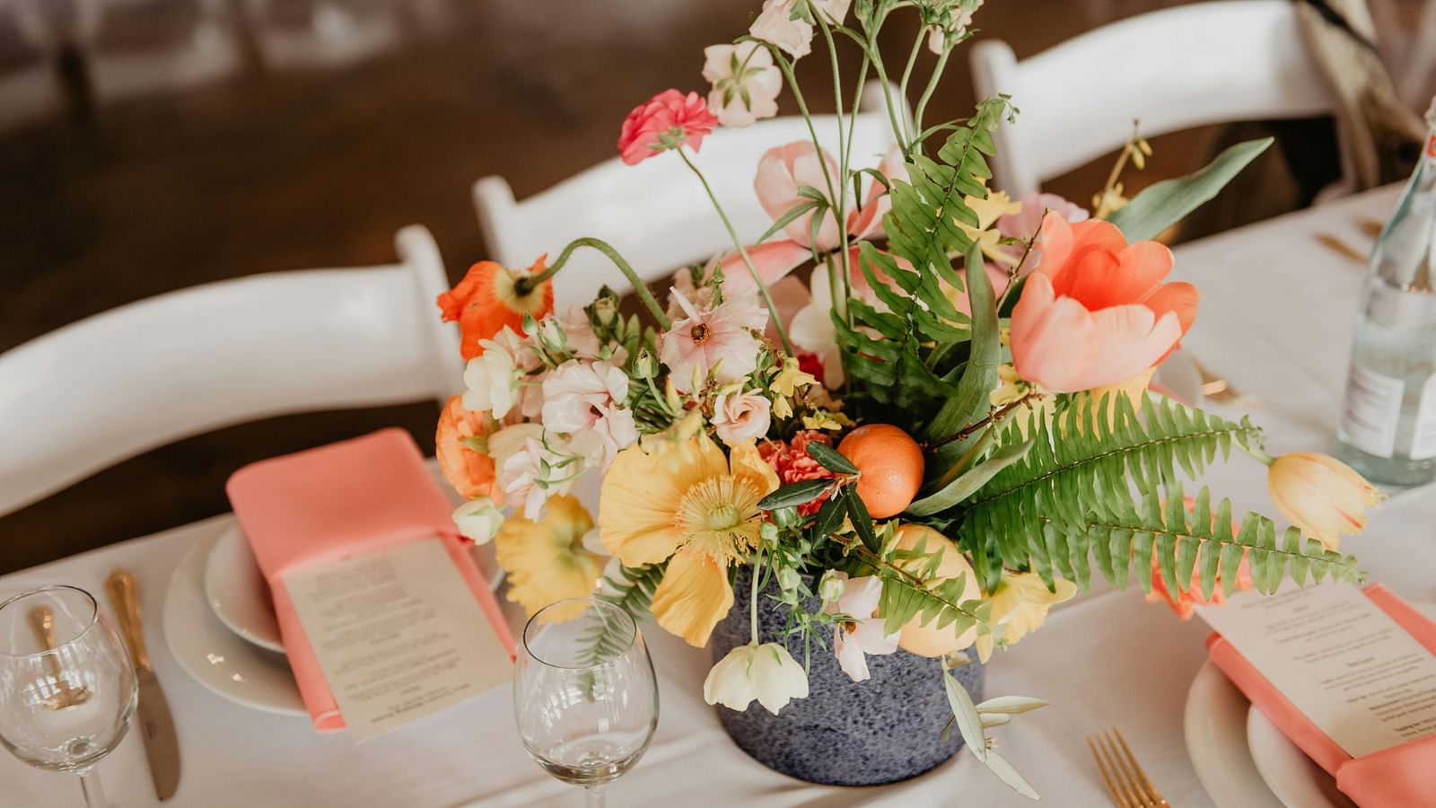 Elegant table setting with vibrant flowers and pink accents for an event