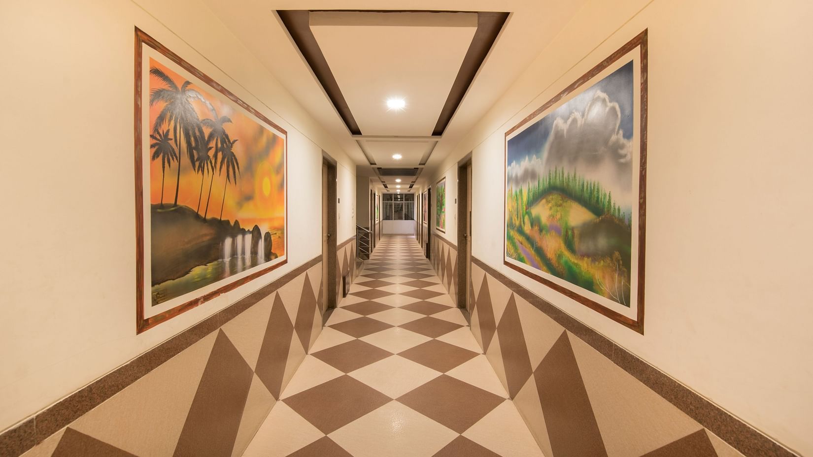 Hotel Vaikunth by Adamo - the lobby area with paintings hanging on either side of the wall