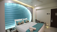 a double bed with a fan on the ceiling inside one of the rooms - VITS Sharanam, Thane