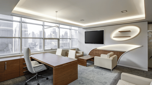 Executive office meeting area with desk, seating, and soft ambient lighting