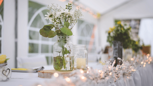 Rosetum - A decorated table at a wedding with flowers in a vase