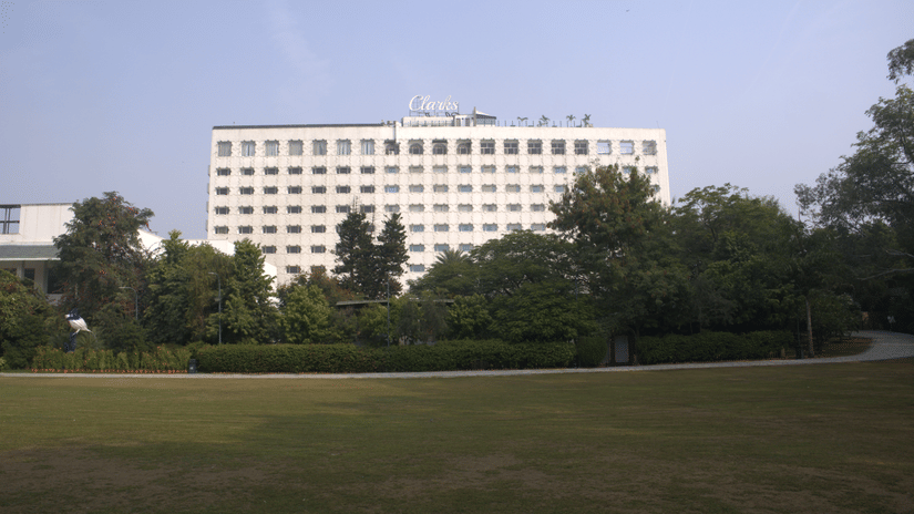 A wide view of the hotel exterior overlooking expansive landscaped lawns, showcasing the property's setting for weddings and outdoor celebrations | Clarks Amer, Jaipur