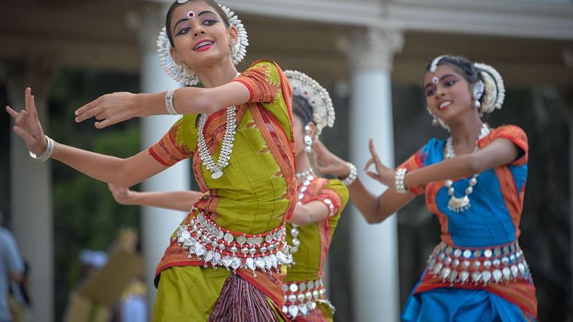 Three ladies wearing sarees and dancing during the day | Odissi dance