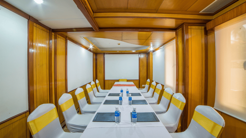 A seating arrangement in a well-lit Amber Conference Room at Raj Park Hotel Alwarpet Chennai with water bottles placed on the table