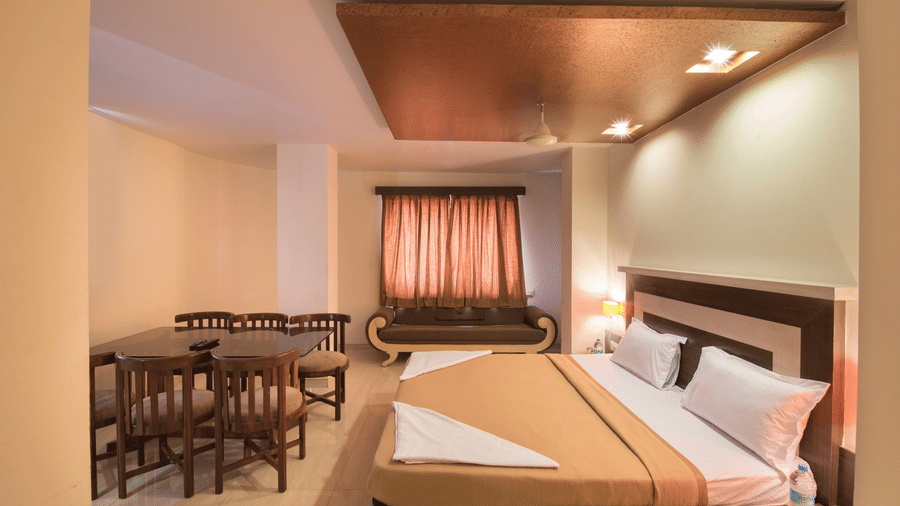 The bedroom offering a bed and a sitting space at the royal suite at Vaikunth by Adamo