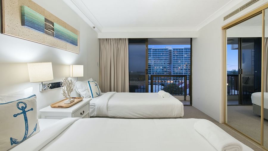 view of twin beds covered in white sheets