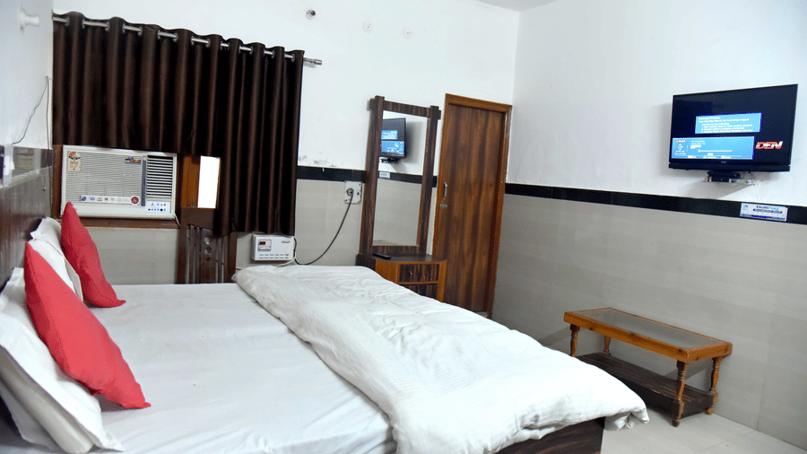 Hotel Goverdhan, Comfortable Stay in Agra - Room featuring double bed, TV mounted on the wall, mirror and table as well as air conditioner - Hotel Goverdhan, Agra