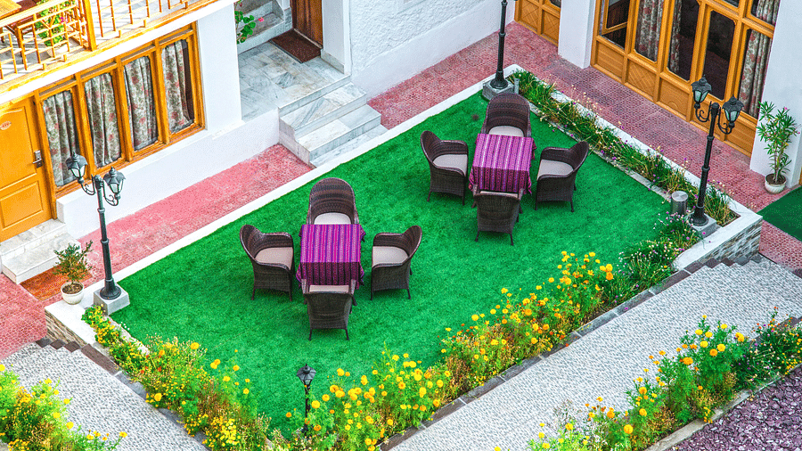 Top view of a garden area with tables and chairs placed on it at Hotel Singge Palace.