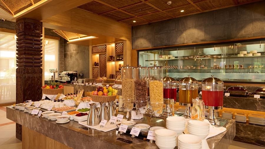 Close-up view of a breakfast buffet with tea, juice dispensers, and crockery - Royal Tulip, Chitwan